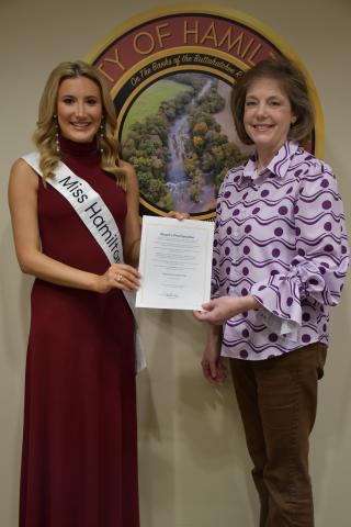 Miss Hamilton Liliana Geier (left) and Hamilton Mayor Tami Lewis Williams hold a proclamation declaring March 16 as “Bullying Prevention Day” in the City of Hamilton.