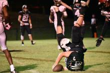 Panther Blaise Vickery crosses the goal line for a touchdown while vertical. Kross Weeks (#4) gives the touchdown signal in the background.