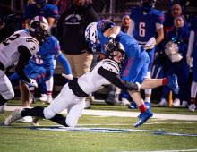 Defensively, Brandon Whitley tackles a Mars Hill player. Also shown is Sean Wyers (#2).